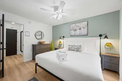 a bedroom with a white bed and a ceiling fan at Fire Ring Private Parking King Beds - Near Ark in Dry Ridge