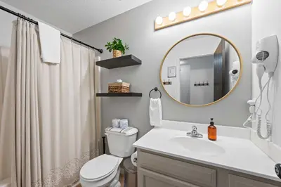 a bathroom with a sink and a toilet and a mirror at Entire Duplex Close to ark with Private Parking in Dry Ridge