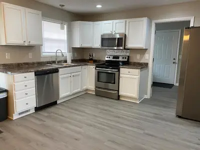 a kitchen with white cabinets and stainless steel appliances at Beautiful Waterfront Ranch in Erie