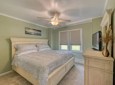 a bedroom with a bed and a ceiling fan at Beach Goers Paradise in Luna Pier