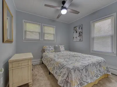 a bedroom with a bed and a ceiling fan at Beach Goers Paradise in Luna Pier