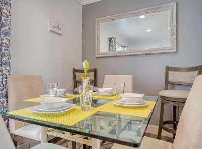 a dining room with a glass table and chairs at Beach Goers Paradise in Luna Pier