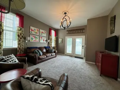 a living room with leather furniture and a chandelier at Battlefield Getaway in Monroe
