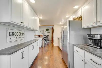 a kitchen with white cabinets and a hard wood floor at Fully Updated! Zanesville Home with River Views in Zanesville