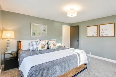 a bedroom with a large bed with pillows at Fully Updated! Zanesville Home with River Views in Zanesville