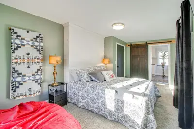 a bedroom with a bed with a white bedspread at Fully Updated! Zanesville Home with River Views in Zanesville