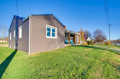 a house on a grassy yard next to a house at Fully Updated! Zanesville Home with River Views in Zanesville