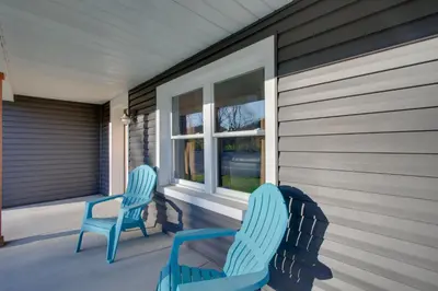 two blue chairs sitting on the porch of a house at Fully Updated! Zanesville Home with River Views in Zanesville