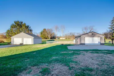 a house with a garage and a large yard at Fully Updated! Zanesville Home with River Views in Zanesville