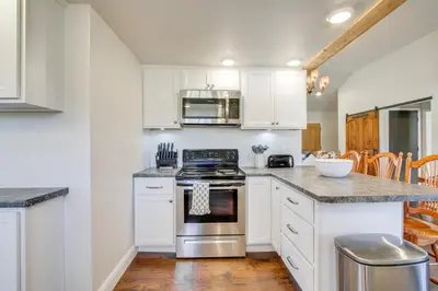 a kitchen with white cabinets and a stove at Fully Updated! Zanesville Home with River Views in Zanesville