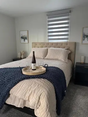 a bed with a bottle of wine and glasses on it at Rise & Shine in Richmond