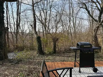 a grill sitting on a wooden deck next to a bench at Rise & Shine in Richmond