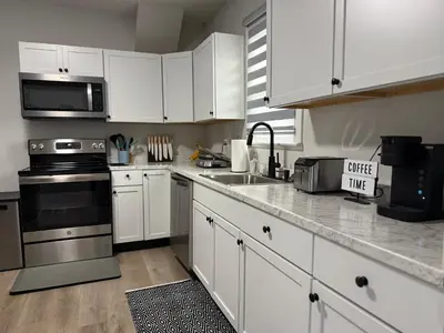 a kitchen with white cabinets and stainless steel appliances at Rise & Shine in Richmond