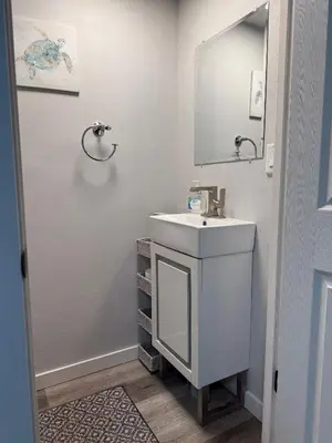 a white bathroom with a sink and a mirror at Rise & Shine in Richmond