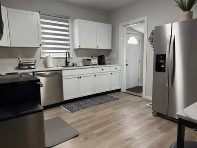 a kitchen with white cabinets and a stainless steel refrigerator at Rise & Shine in Richmond