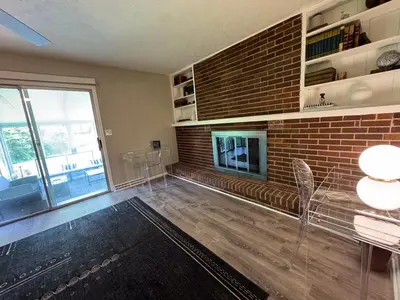 a living room with a fireplace and a brick wall at 3BR Retreat near BrewDog, games, and lots of space in Groveport
