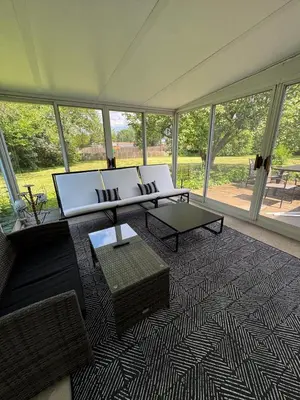 a living room with a couch and tables and windows at 3BR Retreat near BrewDog, games, and lots of space in Groveport