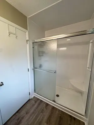 a glass refrigerator in a room with a wooden floor at 3BR Retreat near BrewDog, games, and lots of space in Groveport