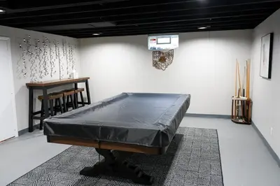a room with a bed in a room with a table at 3BR Retreat near BrewDog, games, and lots of space in Groveport