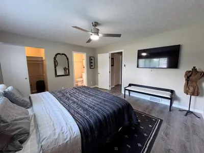 a bedroom with a bed and a flat screen tv at 3BR Retreat near BrewDog, games, and lots of space in Groveport