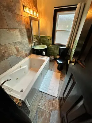 a large bathroom with a tub and a sink at Gem In The Heart of Mill Creek in Youngstown