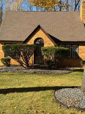 a brown brick house with a black door at Gem In The Heart of Mill Creek in Youngstown