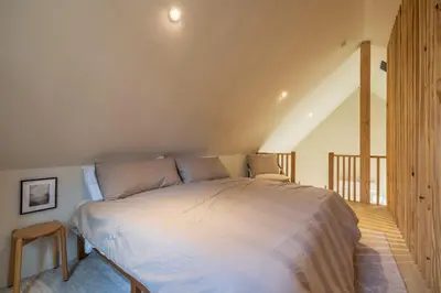 a bedroom with a large bed in a attic at The Klover in Logan