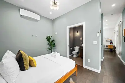 a bedroom with a white bed and a bathroom at Free Downtown Parking Walk to Stadiums and Shopping in Covington
