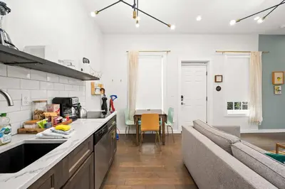 a kitchen and living room with a couch and a table at Free Downtown Parking Walk to Stadiums and Shopping in Covington