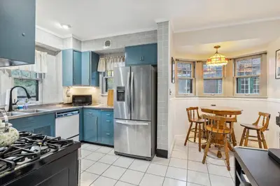 a kitchen with blue cabinets and a table with chairs at Steps to Edgewater - Sleeps 14 - Fun Game Room Retreat in Cleveland