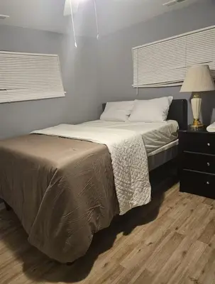 a bedroom with a bed and a table with a lamp at Family size house in Reynoldsburg