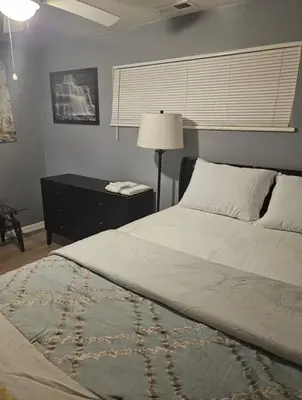 a bedroom with a bed and a table with a lamp at Family size house in Reynoldsburg