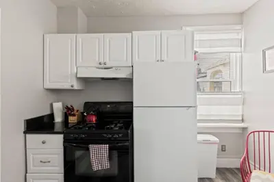 a kitchen with white cabinets and a refrigerator at W38 Front in Cleveland