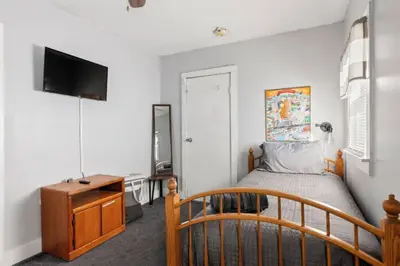 a bedroom with a bed and a dresser and a television at W38 Front in Cleveland