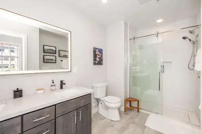 a bathroom with a toilet and a glass shower at The 333 Suites - For 24 Guests in Cincinnati