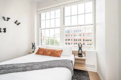 a bedroom with a bed and a large window at The 333 Suites - For 24 Guests in Cincinnati