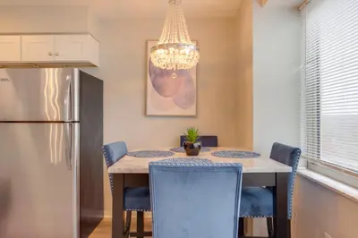 a kitchen with a table with chairs and a chandelier at Cozy 12th-Floor Studio with Lake Erie Views! in Lakewood
