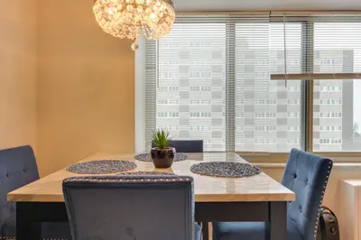 a dining room with a wooden table and blue chairs at Cozy 12th-Floor Studio with Lake Erie Views! in Lakewood