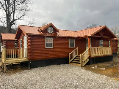 a large log cabin with a porch and a house at Wayne Cabin