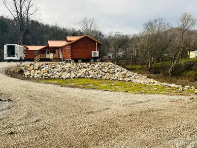 a house with a pile of rocks on the side of a road at Wayne Cabin