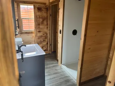 a bathroom with a sink and a tub in a log cabin at Wayne Cabin