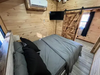 a bedroom with a bed in a wooden wall at Wayne Cabin