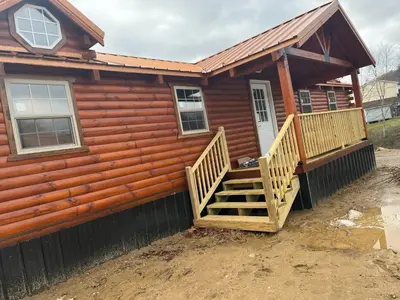 a log cabin with a staircase leading to the front door at Wayne Cabin
