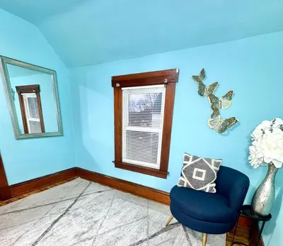 a blue room with a chair and a window at 3 Bedroom Home, near downtown, Tremont, Ohio City! in Cleveland