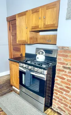a kitchen with a stove and wooden cabinets at 3 Bedroom Home, near downtown, Tremont, Ohio City! in Cleveland