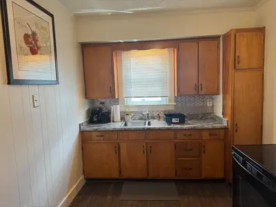 a kitchen with wooden cabinets and a sink and a window at Perfect for Travel Nurses Quiet in Clarksburg