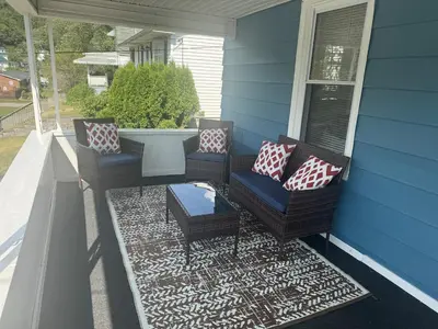a porch with chairs and a table on a house at Cozy 3 4 BR Home Ideal for Family in Clarksburg