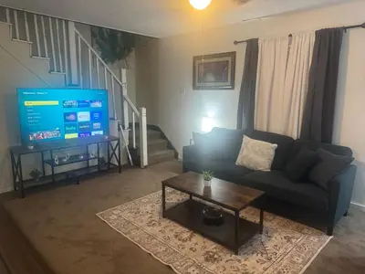 a living room with a couch and a tv at Cozy 3 4 BR Home Ideal for Family in Clarksburg