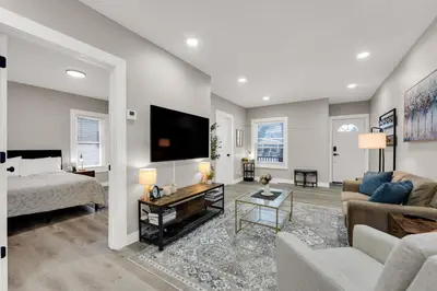 a living room with a couch and a bed and a tv at Family-owned 3BR in Larchmere Near Hospitals with Parking in Cleveland