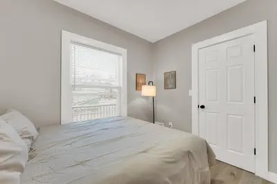 a white bedroom with a bed and a window at Family-owned 3BR in Larchmere Near Hospitals with Parking in Cleveland